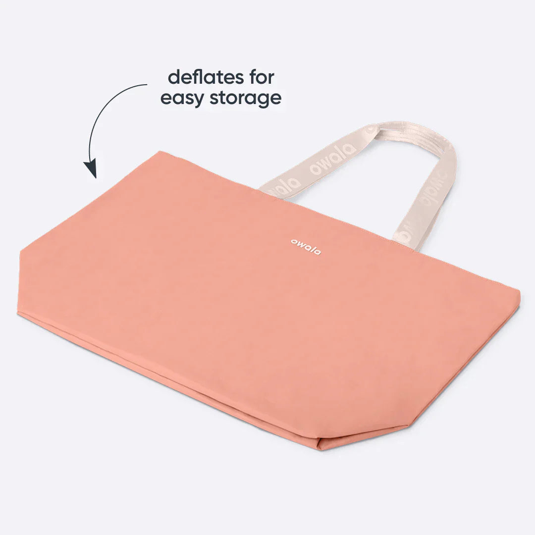 Close-up of the Owala Cloud tote in Rosewood, coral pink puffer-quilted body with blush owala-tape handles featuring repeating Owala logo and Owala logo on the body