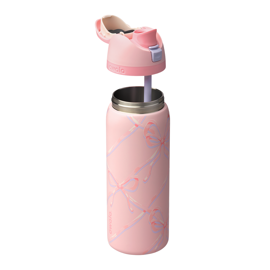 Owala FreeSip 32oz in Sugar Plum Fairy, light pink body with iridescent bow pattern, pink lid open showing cream FreeSip spout and pink carry loop with lilac push-button