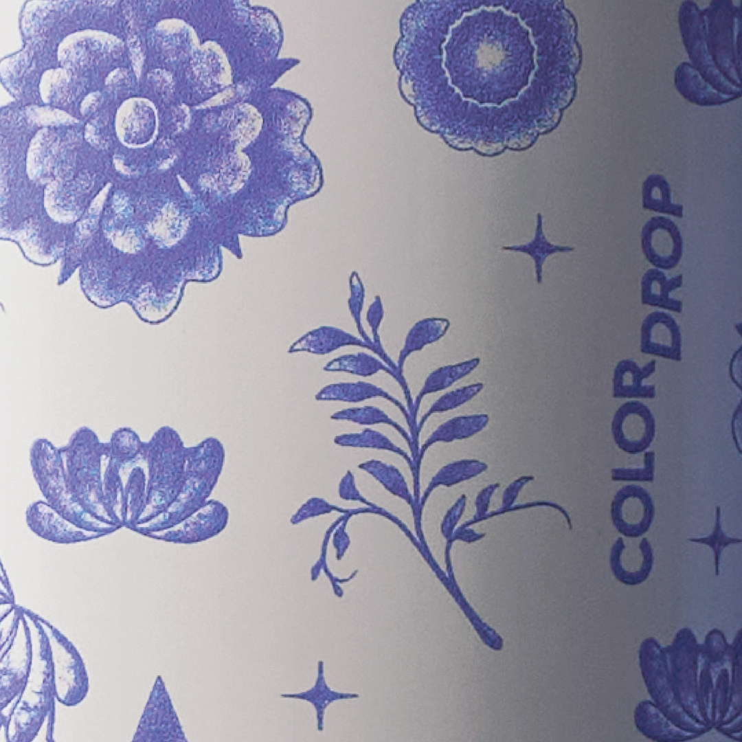 Close-up of cobalt blue floral and medallion pattern over a white body with Color Drop wordmark