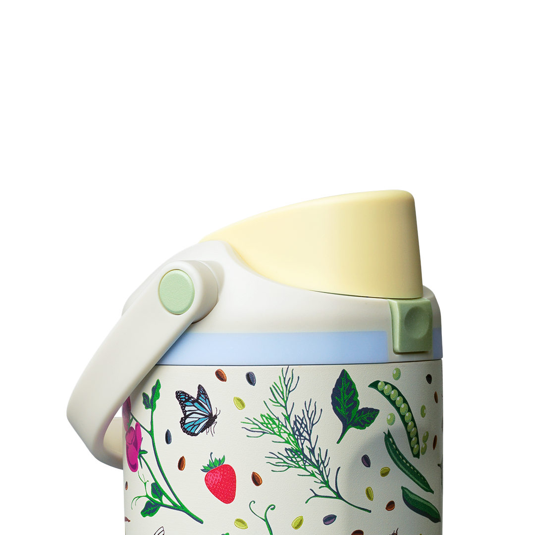 Owala FreeSip Sway 30oz, cream body with garden-themed butterfly, strawberry, leaf, and pea-pod pattern, light blue lid accent ring, butter yellow flip cap, and cream carry loop folded down with sage green swivel detail