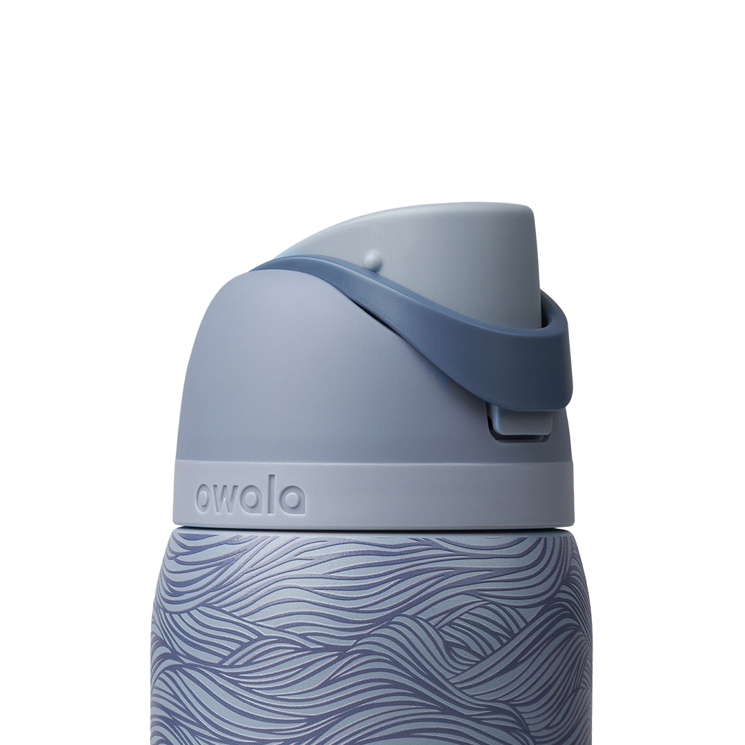 Owala FreeSip 32oz, slate blue body with embossed wave texture, lighter blue-gray lid, slate flip cap, and darker blue carry loop