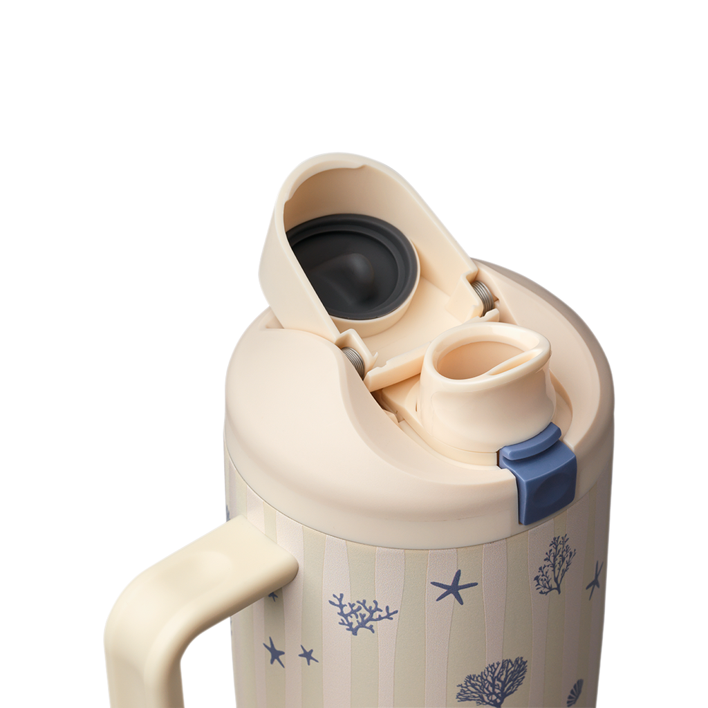 Owala FreeSip Tumbler 30oz in Coral Cabana, cream body with navy coral pattern, flip cap open showing cream FreeSip spout and navy push-button