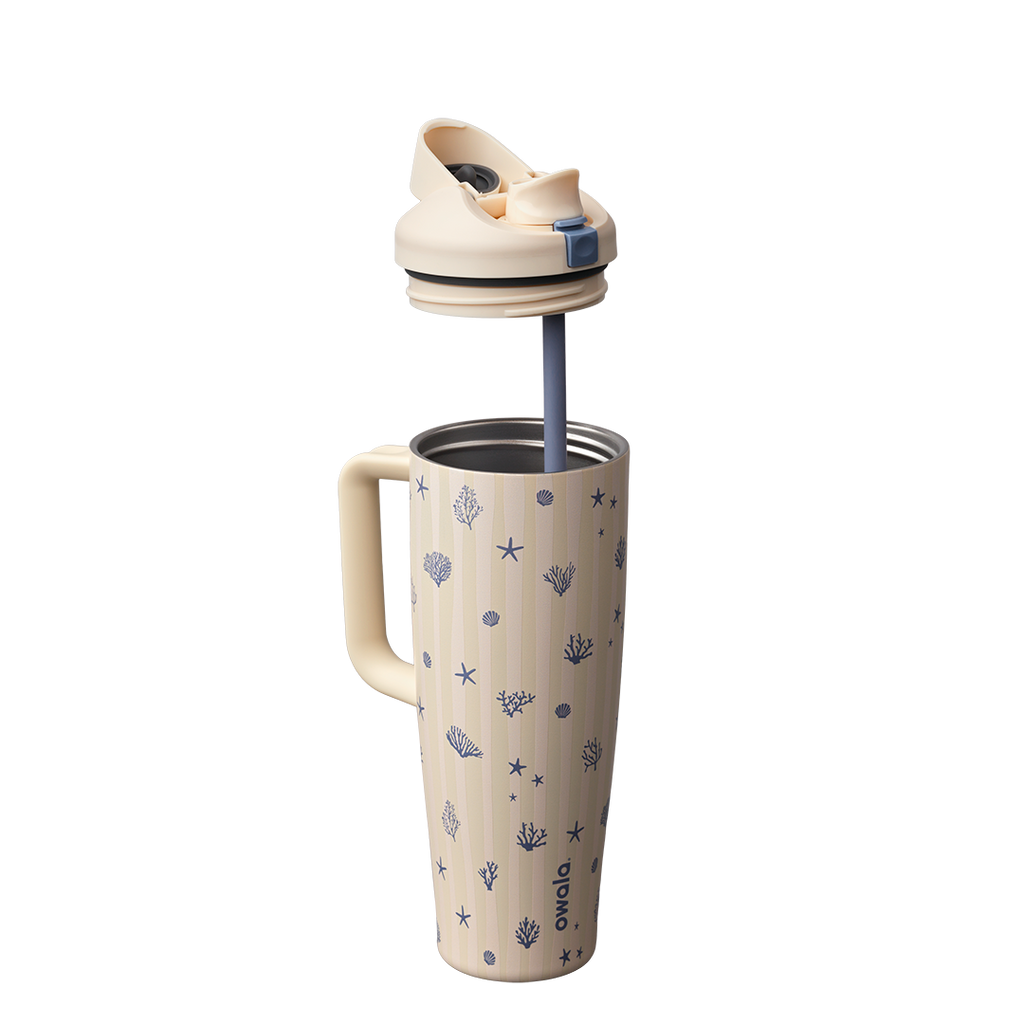 Owala FreeSip Tumbler 30oz in Coral Cabana, cream insulated stainless steel body with navy coral and seashell pattern, shown with cream lid lifted off and navy straw extended