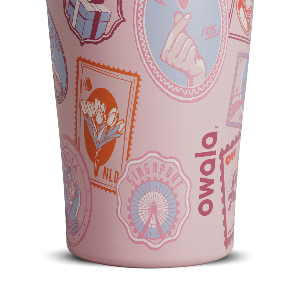 Owala FreeSip Tumbler in Sending Love, pink body with postage-stamp pattern and white Owala logo