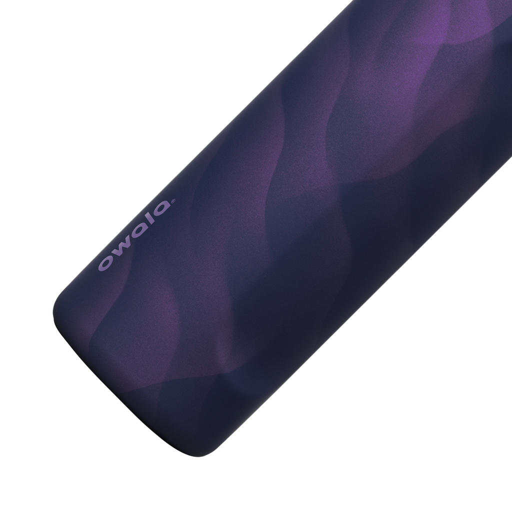 Owala FreeSip 24oz in Arctic Storm, close-up of the deep purple body showing the wavy lavender Color Drop pattern and the Owala logo