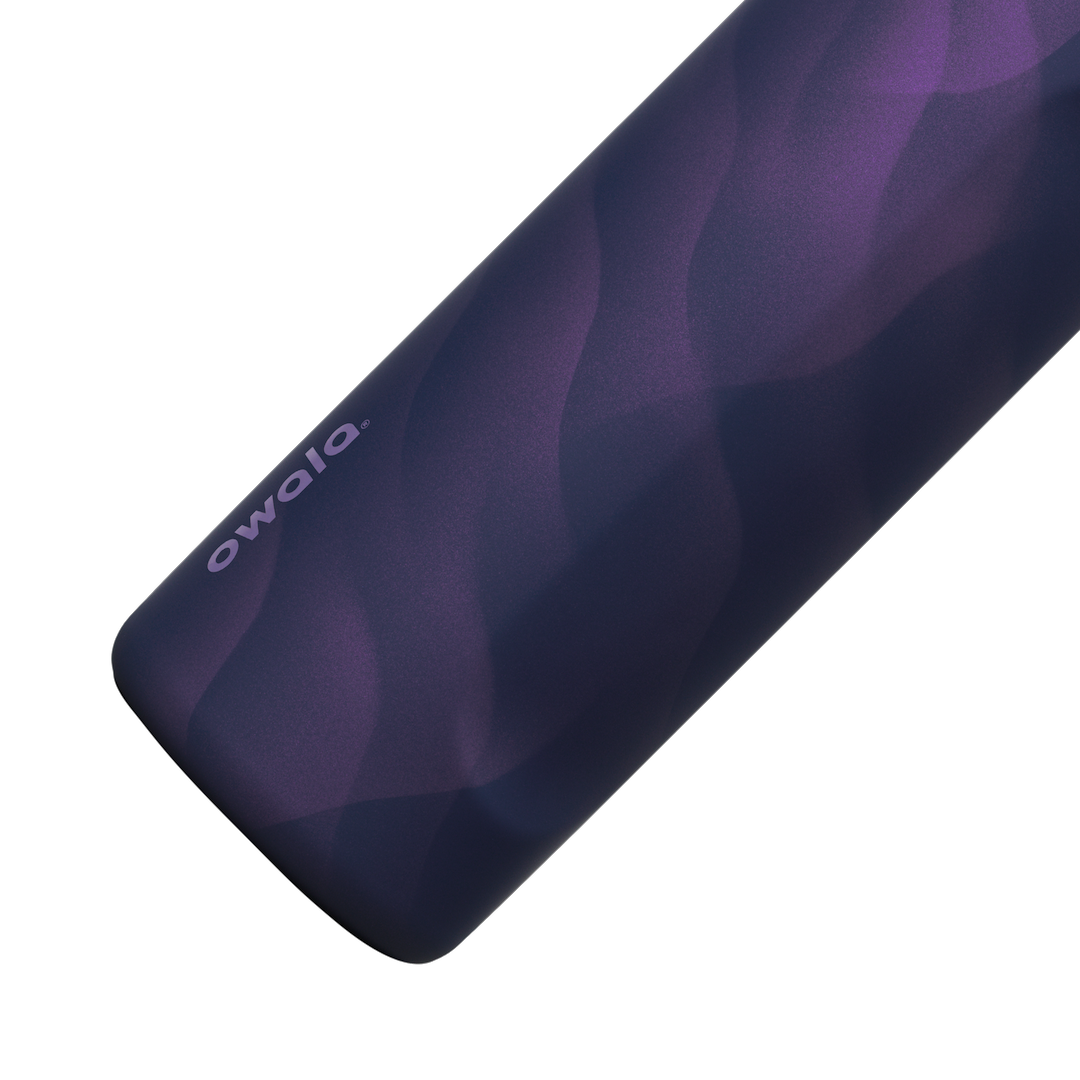Owala FreeSip 24oz in Arctic Storm, close-up of the deep purple body showing the wavy lavender Color Drop pattern and the Owala logo