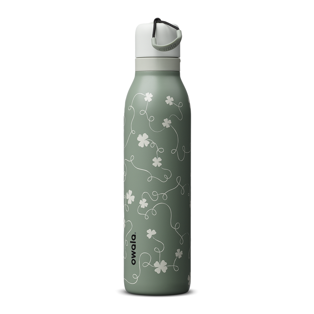 Owala FreeSip Twist 24oz in Clover Achiever, sage green insulated stainless steel body with white clover and vine Color Drop pattern, white twist cap with sage carry string and dark carry string grip