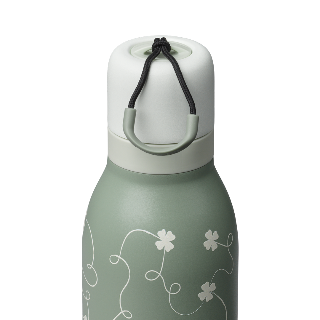 Owala FreeSip Twist 24oz, sage green body with white four-leaf clover pattern, matching sage twist cap and white carry string with sage grip