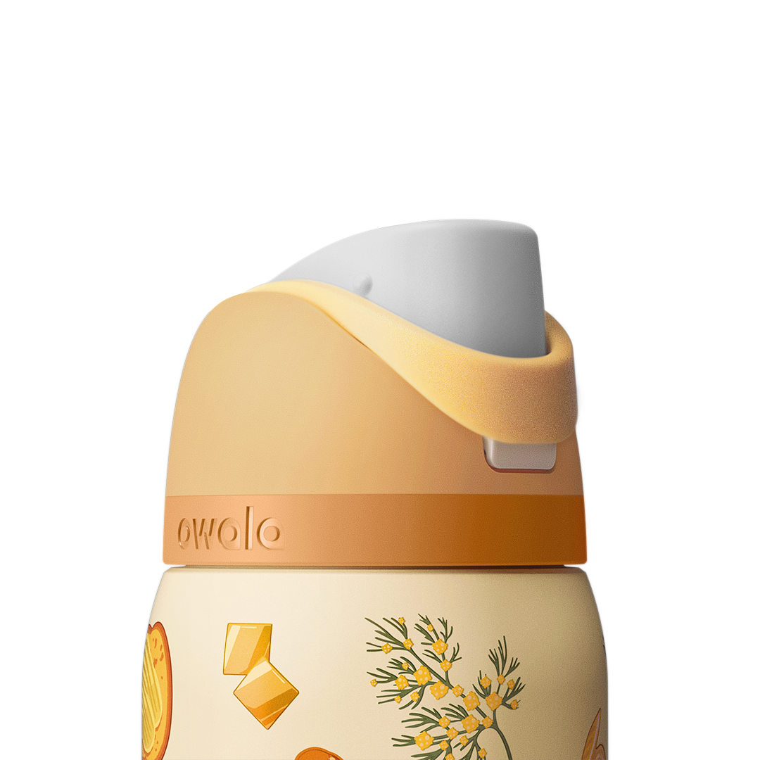 Owala FreeSip 32oz in Brunch Bunch, close-up of the peach flip cap and cream carry loop folded down over the lid