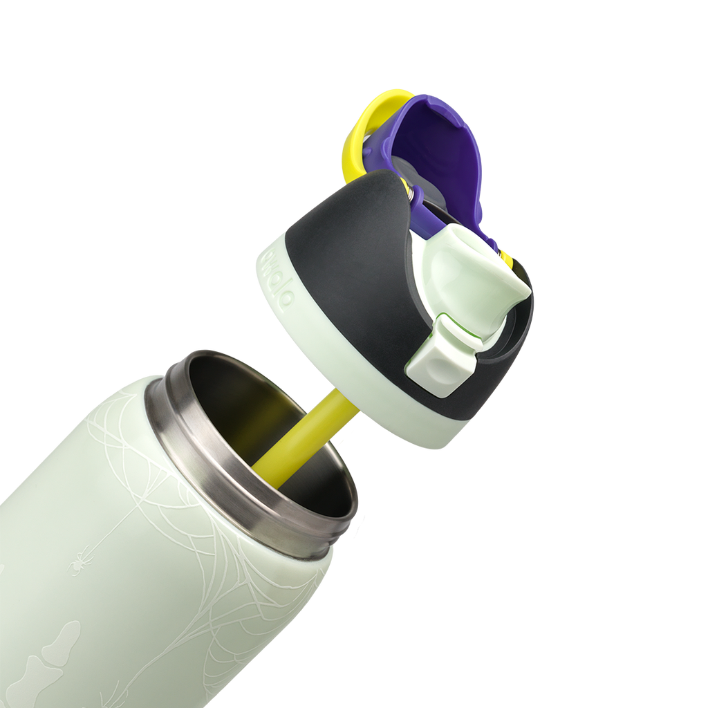Owala FreeSip 32oz in RIP, pale mint insulated stainless steel body with skeleton hand glow print, flip cap open with yellow carry loop showing black lid, pale mint FreeSip spout, and yellow straw extracted; glows in the dark