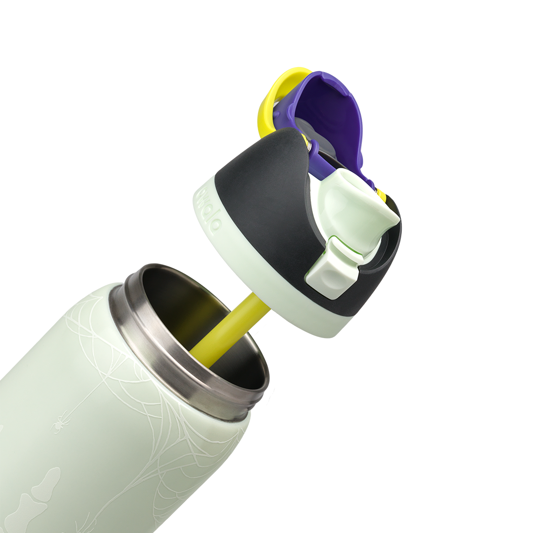 Owala FreeSip 32oz in RIP, pale mint insulated stainless steel body with skeleton hand glow print, flip cap open with yellow carry loop showing black lid, pale mint FreeSip spout, and yellow straw extracted; glows in the dark
