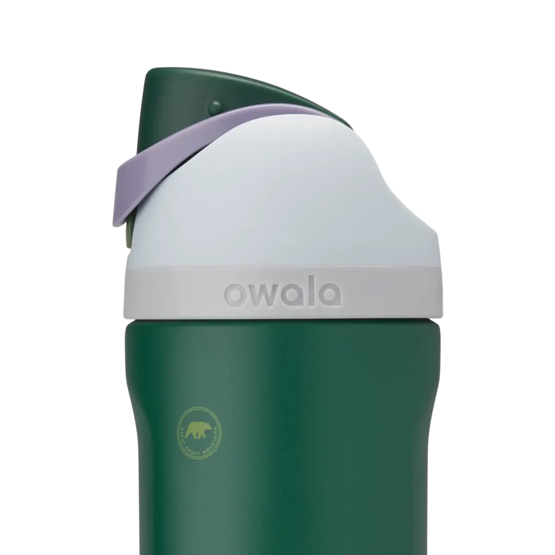 Owala Kids FreeSip 16oz in Great Smoky Mountains, dark forest green insulated stainless steel bottle with white lid, dark green flip cap, lavender carry loop, and small bear graphic on the body