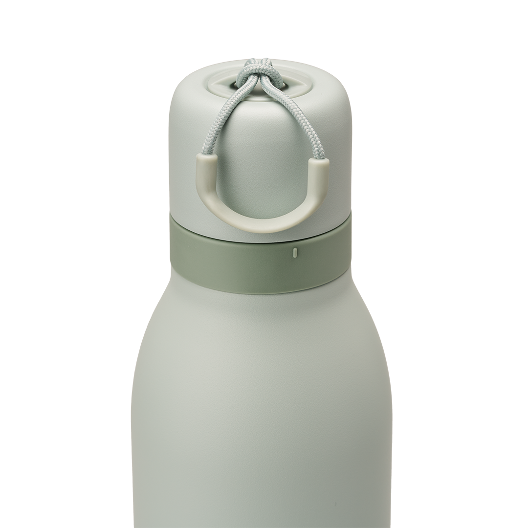 Owala FreeSip Twist 24oz in Summer Paradise, lid detail showing sage green twist cap in place with off-white carry string and carry string grip, darker sage accent band where cap meets the body