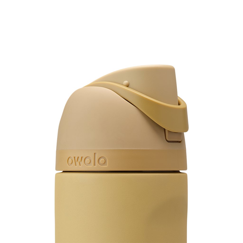 Owala FreeSip 24oz in Autumn Vista, close-up of warm honey-sand lid with matching carry loop in closed position