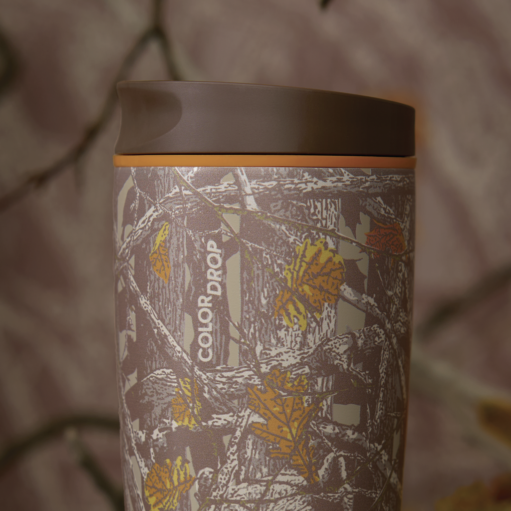 Owala SmoothSip Slider in Out of Sight, woodland camo patterned body with orange lid accent ring and brown flip cap, COLOR DROP text visible on body